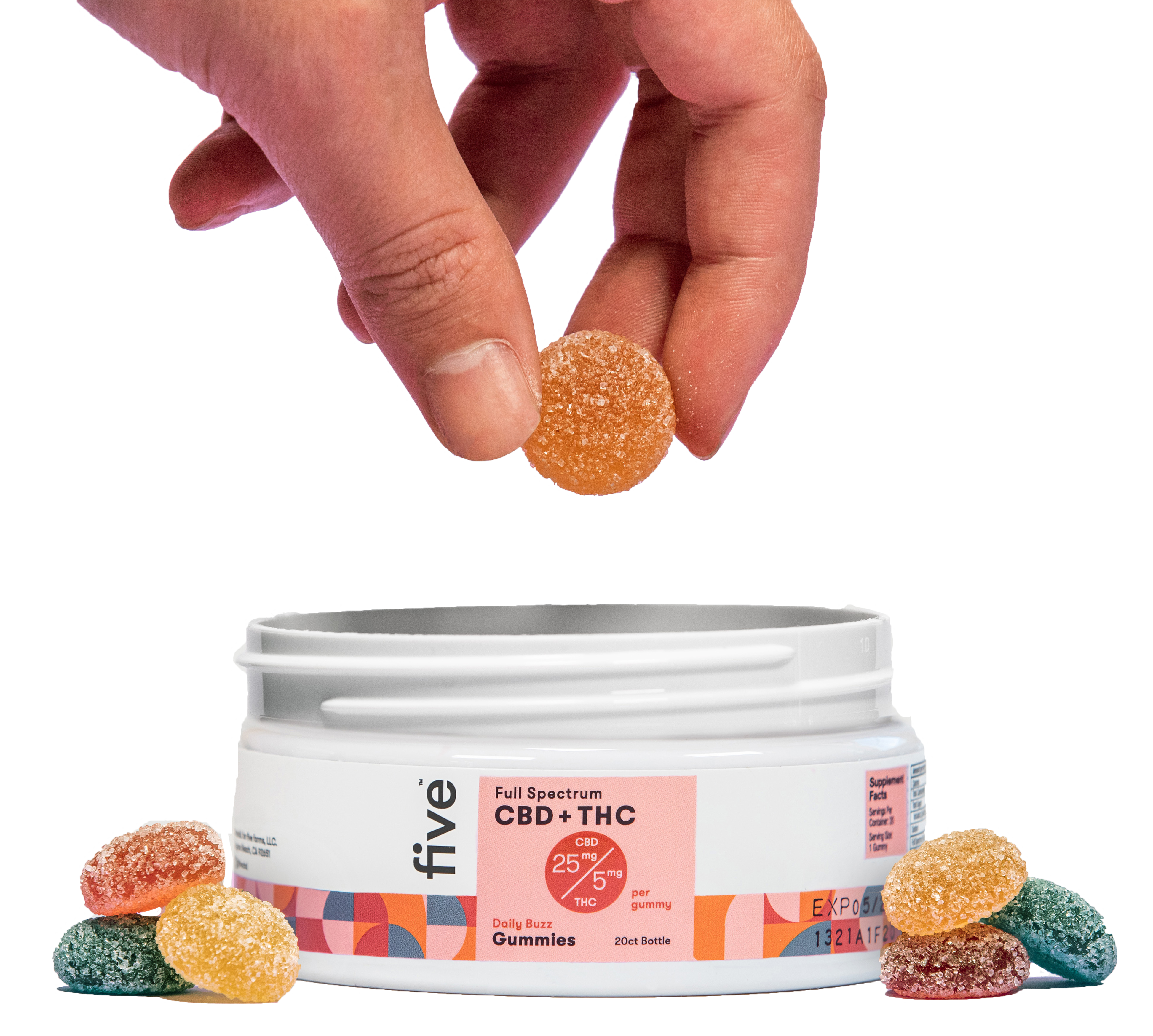 A hand reaching into an open container of Five brand Daily Buzz gummies. The white container is labeled with dosage information, and a few multicolored sugar-coated gummies are placed outside the jar